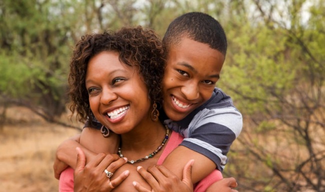 Happy mother and son embracing with large smiles